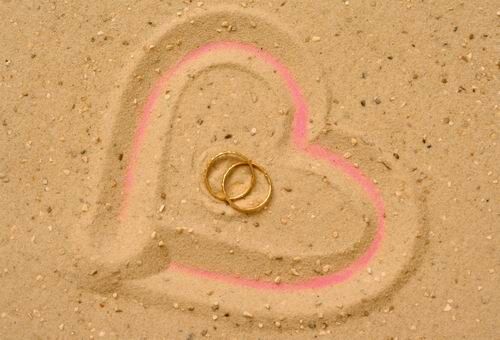 Herzen und Ringe im Sand